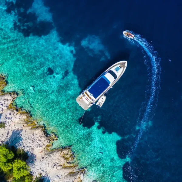 Aerial view of a boat anchored in a turquoise Adriatic bay in Croatia